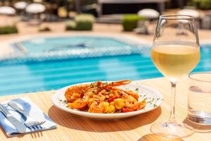 a plate of shrimp on a table with a glass of wine at Gitavillage Argentario in Albinia