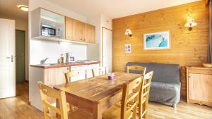 a kitchen and dining room with a wooden table and chairs at V du Bachat Silenes B11 Appt belle vue 4 6 pers in Chamrousse