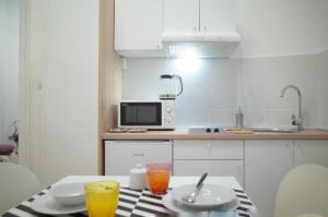 eine Küche mit einem Tisch mit Getränken und einer Mikrowelle in der Unterkunft Sedaki Apartments in Zagreb