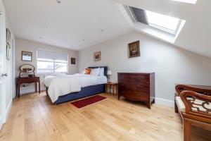 a bedroom with a bed and a dresser and a window at Stylish 3 BDR apartment wfree parking and garden in Kingston upon Thames