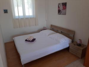 a bedroom with a bed with a pair of shoes on it at Apartments Pavelic in Povile