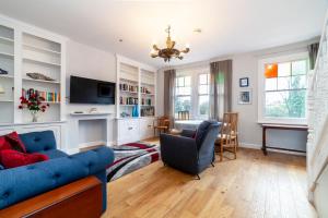 a living room with a blue couch and a tv at Stylish 3 BDR apartment wfree parking and garden in Kingston upon Thames