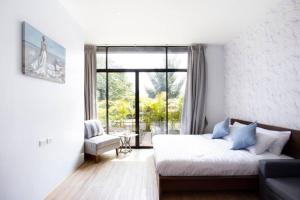 ein Schlafzimmer mit einem Bett und einer Couch und einem Fenster in der Unterkunft Bangkok Luxury Pool Villa Thonglor in Bangkok + 48 Fotos