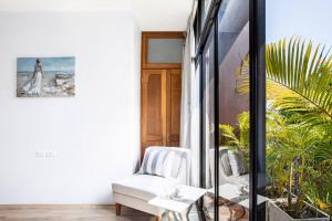 Zimmer mit einem weißen Stuhl und einem Fenster in der Unterkunft Bangkok Luxury Pool Villa Thonglor in Bangkok