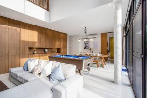 ein Wohnzimmer mit einer Couch und einem Billardtisch in der Unterkunft Bangkok Luxury Pool Villa Thonglor in Bangkok