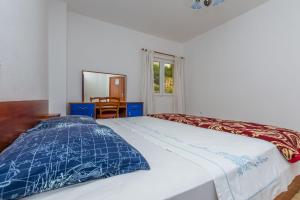 a bedroom with a white bed with a blue comforter at Apartment Anica in Omiš