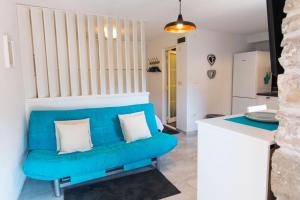 ein blaues Sofa im Wohnzimmer mit Küche in der Unterkunft Apartment Penny in Stomorska