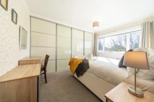 una camera con letto, scrivania e finestra di Charming 4-Bedroom House-York a Stockton on the forest
