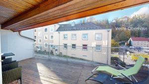 einen Balkon mit einem grünen Stuhl und einem Gebäude in der Unterkunft Hufschmieds Bleibe in Passau