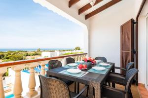 a dining room with a table and chairs on a balcony at Villa María in Son Bou
