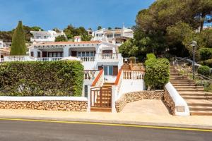 a large white house with stairs and bushes at Villa María in Son Bou
