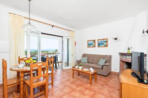 a living room with a couch a table and a television at Villa María in Son Bou