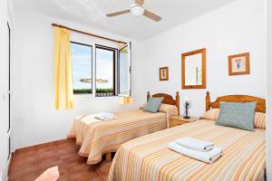 two beds in a room with a window at Villa María in Son Bou +22 photos