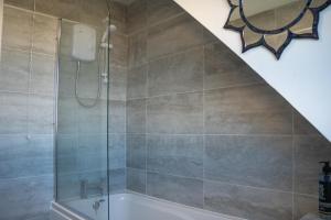 a bathroom with a shower and a bath tub at Well-furnished 3-Bedroom house with Free Parking and Sky TV in Milton Keynes by HP Accommodation in Milton Keynes