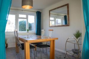 - une table à manger avec des chaises et un miroir dans l'établissement Well-furnished 3-Bedroom house with Free Parking and Sky TV in Milton Keynes by HP Accommodation, à Milton Keynes