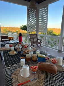 einen Tisch mit Speisen und Getränken auf der Veranda in der Unterkunft La maison d'hôte de la Forêt Retrouvée in Mahajanga