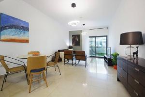 een woonkamer met een tafel en stoelen en een eetkamer bij Skyline Views 1 Bedroom Apartment Lake Facing in Dubai