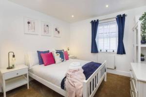 a bedroom with a white bed and blue curtains at York City Apartments in York