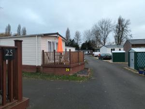 une maison avec une terrasse munie d'un parasol orange dans l'établissement 24 Shark Island, à Great Billing