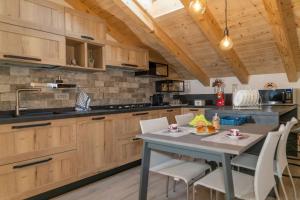 a kitchen with wooden cabinets and a table with chairs at Villa Floris in Castello Tesino