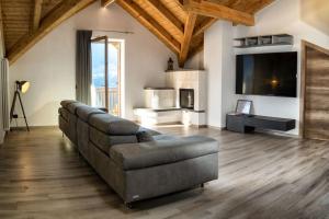 a living room with a couch and a television at Villa Floris in Castello Tesino