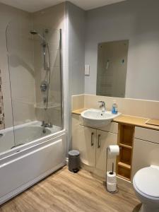 Belgrade Plaza Serviced Apartments في كوفينتري: حمام مع حوض استحمام ومغسلة ومرحاض +15 صورة