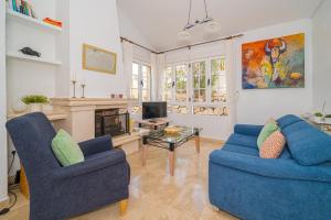 a living room with two blue chairs and a fireplace at Casa Pia in Orihuela Costa