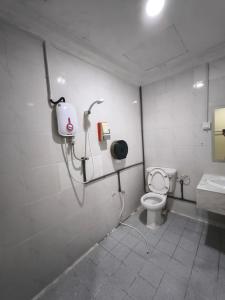 La salle de bains est pourvue de toilettes blanches et d'un lavabo. dans l'établissement OYO 90895 Hotel Ikia, à Kampong Bagan Dalam