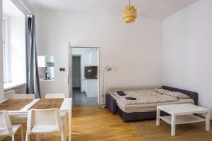 1 dormitorio con 1 cama, mesa y sillas en Vienna Living Apartments - Barnabitengasse, en Viena