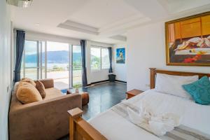 um quarto com uma cama e um sofá em Patong Blue House Panorama View em Praia de Patong
