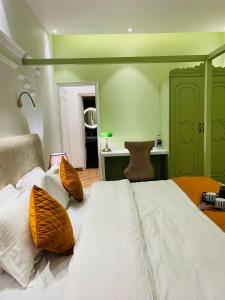 duże łóżko z białą pościelą i pomarańczowymi poduszkami w obiekcie Victorian Elegance Luxury Stays w mieście Amritsar