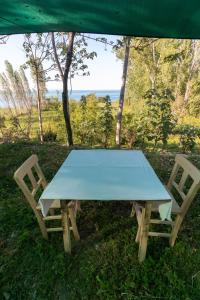 een picknicktafel en twee stoelen onder een tent bij Deydaa Ekoloji Kampı in Gerze