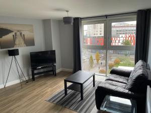 a living room with a couch and a television at Belgrade Plaza Serviced Apartments in Coventry