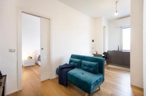 Una sala de estar con un sofá azul en una habitación. en Milano Affori - Stile e comfort, en Milán
