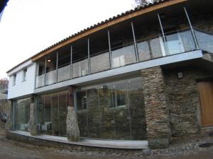 un edificio con ventanas de cristal en un lateral en Quinta dos Castanheiros - Turismo Rural, en Negreda