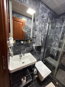 ein Bad mit einem Waschbecken, einer Dusche und einem WC in der Unterkunft Basilissis Hotel in Istanbul