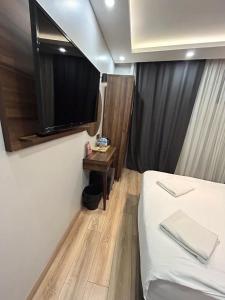 um quarto com uma cama e uma televisão na parede em Basilissis Hotel em Istambul