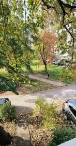 een weg in een park met bomen en een parkeerplaats bij Park View Apartment in Skopje