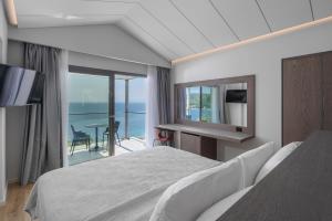 Schlafzimmer mit einem Bett und Meerblick in der Unterkunft Adrina Grand Hotel in Panormos Skopelos