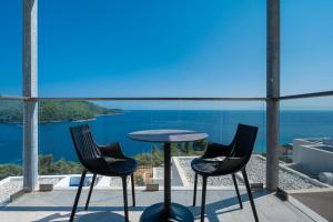 two chairs and a table on a balcony overlooking the ocean at Adrina Grand Hotel in Panormos Skopelos