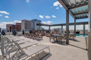 un patio con mesas y sillas en la azotea en City Living Modern Apartments at Kenect Phoenix en Phoenix