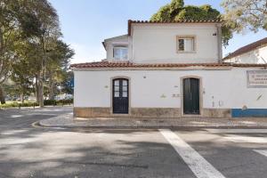 a white building on the side of a street at Jardim da Parada in Cascais