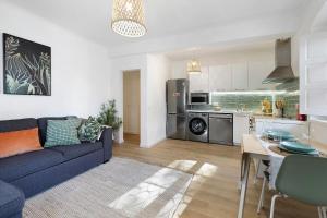 a living room with a blue couch and a kitchen at Jardim da Parada in Cascais +12 photos