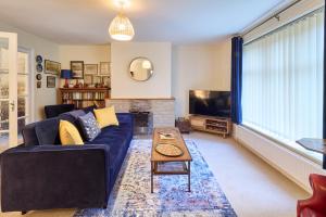 a living room with a blue couch and a tv at Host & Stay - Mayfield in Blean