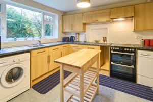 a kitchen with wooden cabinets and a wooden stool at Host & Stay - Mayfield in Blean