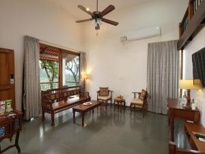 un soggiorno con sedie e ventilatore a soffitto di Tapovana The Fern Heritage Resort, Sakleshpur a Sakleshpur