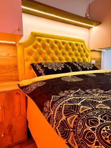 ein Schlafzimmer mit einem großen Bett mit einem gelben Kopfteil in der Unterkunft Zlatni apartman Borovi in Divčibare