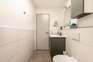 Baño blanco con aseo y lavamanos en Voldewraa Wohnung 5 en Husby