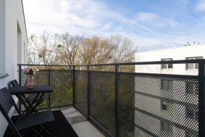 a balcony with a black fence and a table on a balcony at Apartment with 2 Bedrooms and FREE GARAGE Poznań by Renters in Poznań