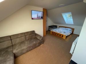 Hotel Antler في Studénka: غرفة معيشة مع أريكة وسرير